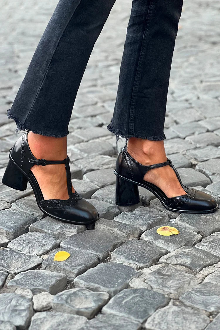 Schwarze Pumps mit breitem Absatz und runder Spitze, einfarbig mit Schnalle und T-Riemen" 

Here’s a rewritten version: 

"Schwarze Pumps mit breitem Absatz und runder Spitze, einfarbig, mit Schnalle und T-Riemen-Design